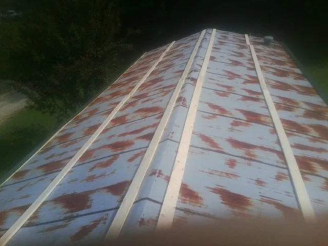 Rusted metal roof panels with new wood purlins before replacement — Storm Damage Roof Repair in Lime Ridge by Roofing Brothers