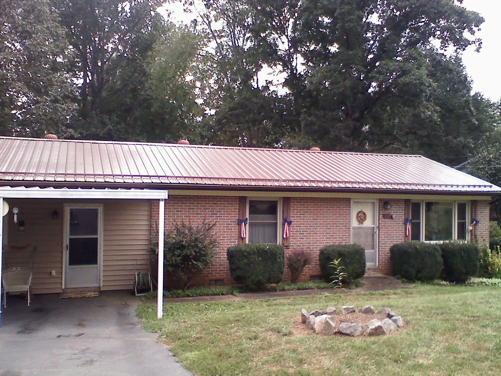 Bronze metal roof and carport on a brick ranch home — Roof Repair work by our crew in Lime Ridge